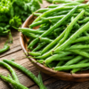 Fresh green beans at Don-O-Ray Farms in Kelowna, displayed in a wooden bowl with vibrant farm-fresh produce.